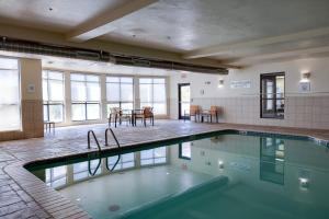 a swimming pool in a room with a table and chairs at Courtyard by Marriott Oklahoma City North/Quail Springs in The Village