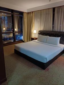 a large bed in a hotel room with windows at Kuala Lumpur Grand service suite at Times Square in Kuala Lumpur +35 photos