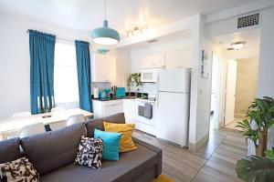 Una sala de estar con un sofá y una cocina. en 3 Minute Walk to Beach 2 Bedroom Apartment Family Friendly with No Pet Fee, en Miami Beach