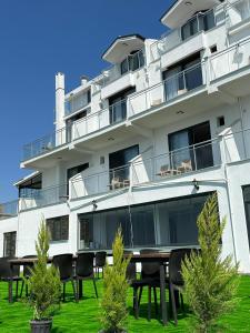a building with chairs and tables in front of it at Pavlonya Garden in İntepe