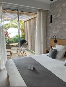 a bedroom with a large bed and a balcony at Hôtel L'Albatros in Saint-Trojan-les-Bains