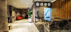 a lobby with a marble counter and an orange couch at MIRAFLORES CITY HOTEL in Lima