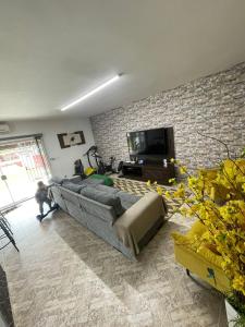 a living room with a couch and a flat screen tv at Chácara Boa Vista Santa Isabel SP in Santa Isabel