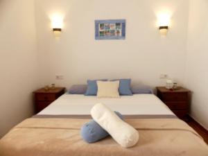 una camera da letto con un letto con un cuscino sopra di Warung a Lajares