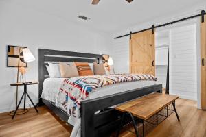 a bedroom with a large bed and a wooden table at Home & Vine - Hot Tub Fire Pit & Outdoor Oasis in Fredericksburg +78 photos