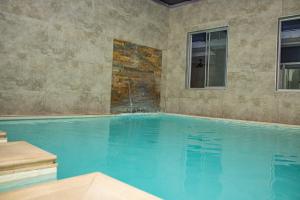 a large swimming pool with a stone wall at The Inn by Ilawu in Pietermaritzburg