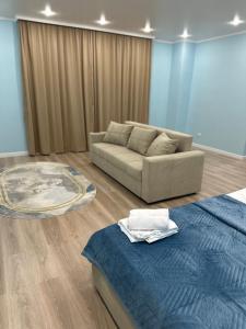 a living room with a couch and a bed at ЖК Комсомольский in Astana