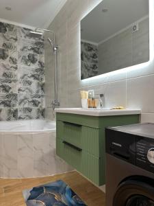 a bathroom with a sink and a tub and a washing machine at ЖК Комсомольский in Astana
