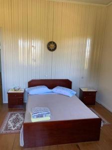 a bedroom with a bed with two tables and a clock on the wall at Colonia Nona Angélica in Farroupilha