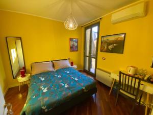 ein Schlafzimmer mit einem Bett in einem gelben Zimmer in der Unterkunft Amici Miei Rooms in Cremona