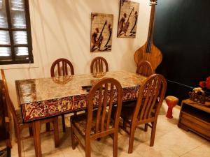 a dining room table with chairs and a guitar at Dar Margoum in Tozeur
