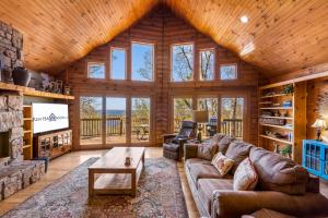 Cabaña de madera con sala de estar con sofá y chimenea en Hideaway Lodge, en Ridgedale