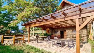 a patio with chairs and a wooden pergola at Villa Cserhegy Vendégház Tihany in Tihany