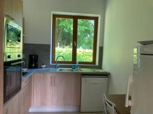a kitchen with a sink and a window at La maison des fleurs in Saint-Arnoult