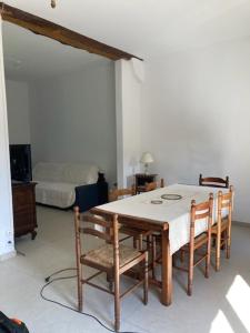 a dining room with a table and chairs and a bed at La maison des fleurs in Saint-Arnoult
