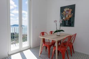 a dining room with a table and red chairs at "Torretta House", inside a Private Park, shared Pool, Tennis, AC, parking next home and parking in Lerici! in Lerici