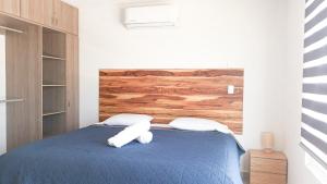 a bedroom with a blue bed with two white towels at Acapulco diamante, club de playa privado, canchas pádel para 8 huéspedes in Acapulco +54 photos