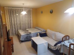 Una pequeña habitación con una cama y un sofá. en TU CASA EN MEQUINENZA CON WIFI, en Mequinenza 30 fotos más