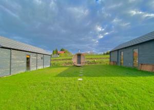 a large yard with two buildings and a grass field at Uroczy zakątek in Silice +5 photos