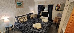 - une chambre avec un lit et 2 chaises dans l'établissement Fantastic sea views at Century's old Alma's Cottage - Sleeps up to 8 guests, à Penmaen-mawr