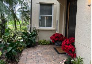 a porch with red flowers and a window at Paradise Gem in Naples