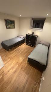 two beds in a room with a wooden floor at Vassfjellet Home in Trondheim