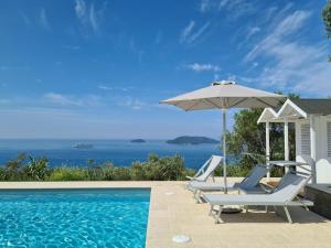 a swimming pool with two chairs and an umbrella at "Torretta House", inside a Private Park, shared Pool, Tennis, AC, parking next home and parking in Lerici! in Lerici