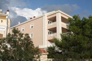 a building with trees in front of it at Pinna Nobilis Apartments - Ground Floor in Brodarica