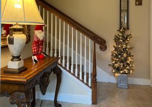 a staircase with a christmas tree and a lamp on a table at Paradise Gem in Naples