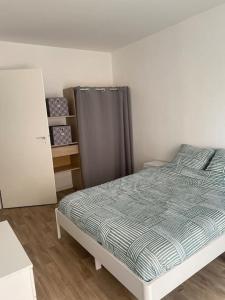 una camera con letto e tenda grigia di Location Appartement T3#1 a Pierrefitte-sur-Seine