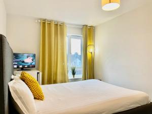 a bedroom with a bed and a tv and a window at Luxury Rooms In Furnished Guests-Only House Free WiFi West Thurrock in Grays Thurrock