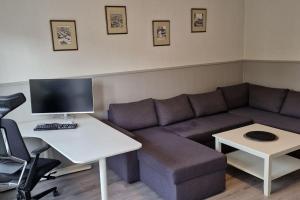 a living room with a couch and a desk with a computer at Central 2 bedroom apartment in Lillehammer
