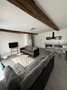 a living room with a couch and a table at Le Grand Mauperthuis F4 in Forges