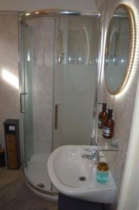 a bathroom with a sink and a shower with a mirror at Love room or et rouge in Airan +8 photos