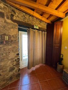 a room with a stone wall and a window at Casa do Arco da Velha in Bragança