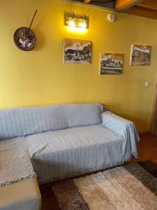 a living room with a couch and a yellow wall at Casa do Arco da Velha in Bragança