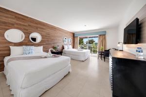 a hotel room with two beds and a flat screen tv at Playa Blanca Beach Resort - All Inclusive in Playa Blanca +91 photos