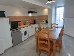 a kitchen with a wooden table and a dining room at Entre Tours et Loches in Tauxigny