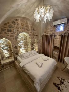 a bedroom with a large bed with a chandelier at Miri Cave Suite in Mardin +20 photos