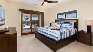 a bedroom with a bed and a desk and a window at ALOHA SHORES Spacious Ainamalu 4BR Home with Mountain and Ocean View in Waikoloa +58 photos