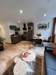 a living room with a couch and tables and a kitchen at Atelier du spa jacuzzi illimité proche du mont saint Michel in Avranches +11 photos