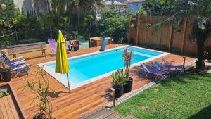 a swimming pool with a wooden deck and a swimming poolvisor at Casa Aconchegante e Inteligente na Cachoeira in Florianópolis