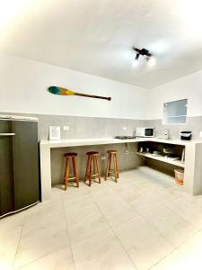 a kitchen with a counter and stools in it at Villa Bali Maresias Lofts in Maresias +58 photos