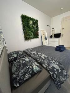 een bed met twee kussens en een schilderij aan de muur bij Studio proche du centre-ville in Straatsburg