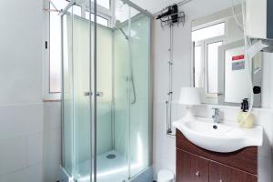 Un baño con ducha de cristal y lavabo. en Divine House of Graça, en Lisboa