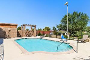 a swimming pool with chairs and a light pole at Best Western California City Inn & Suites in California City
