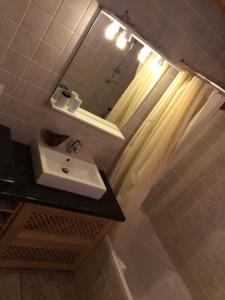 W łazience znajduje się umywalka i lustro. w obiekcie Appartement Du Dou Des Ponts w mieście Pralognan-la-Vanoise