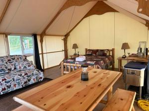 Zimmer mit einem Holztisch in einem Zelt in der Unterkunft Howling Wolf Resort in Seward