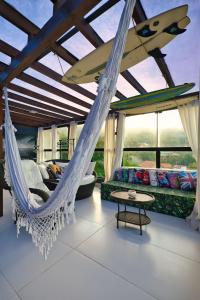 a room with a hammock with a surfboard on it at Residencial Vale do Sol in Garopaba