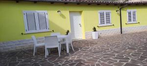 a table and chairs in front of a yellow house at Casa gialla in LʼAquila +3 photos